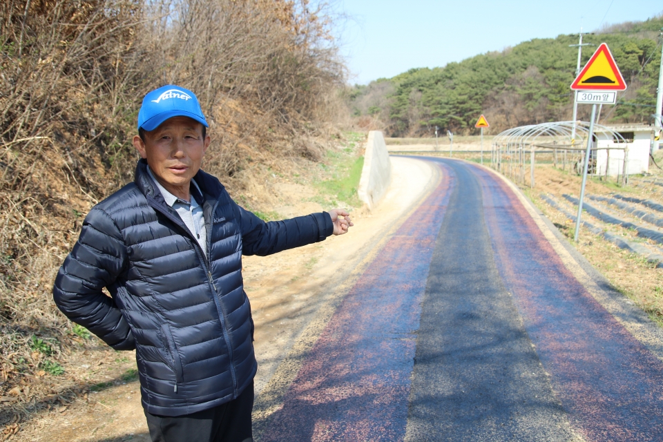 수청동에서 이곳 마을을 통과하는 1차선 도로의 불편함을 설명하는 김찬기 시곡 1통 통장