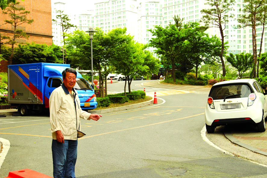 아파트 단지 내 곡선도로의 불편함을 설명하고 있는 김덕성 통장