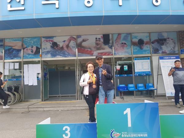 실명이라는 장애를 가진 김순례 씨가 충남장애인체전 수영대회에 출전해 3등이라는 값진 결실을 얻고 남편과 함께 기념사진을 찍고 있다.