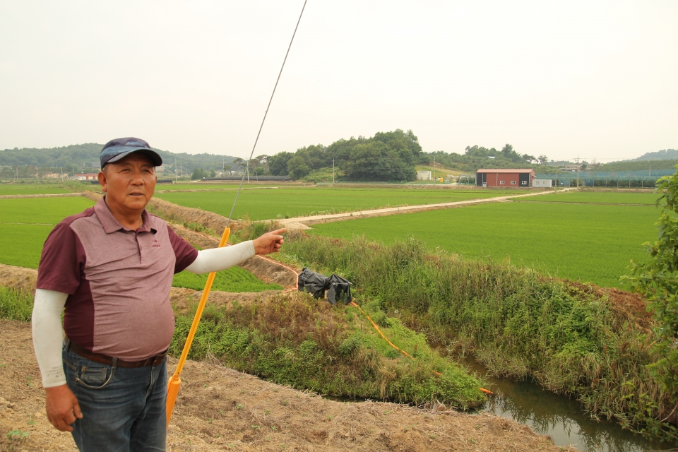 배수로에 설치된 모터기가 농사철 농업용수를 대신하고 있다고 설명하는 김대원 이장.