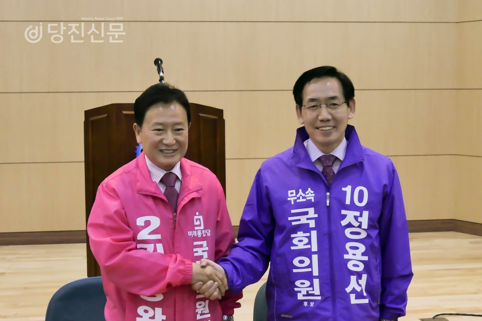 미래통합당 김동완 후보와 무소속 정용선 후보가 협약서에 서명한 후 악수하고 있는 모습.