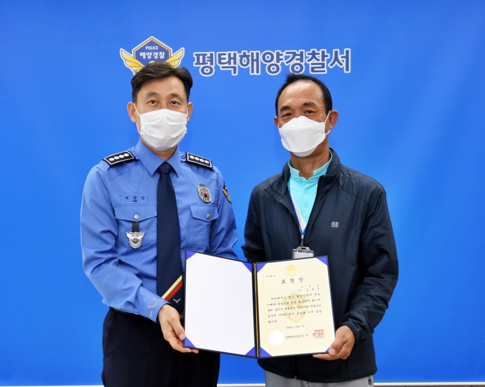 이상인 평택해양경찰서장(왼쪽)가 충남 당진시 맷돌포구에서 소중한 생명을 구한 김용주 씨에게 표창장을 수여한 뒤 기념사진을 찍고 있다.