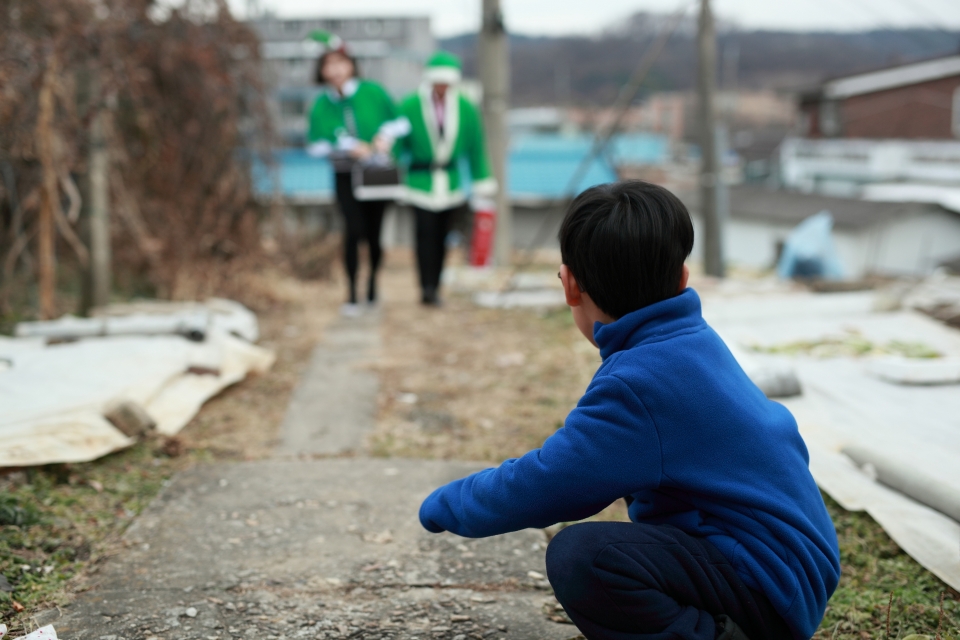 한 아이가 초록우산 산타원정대를 기다리고 있다.
