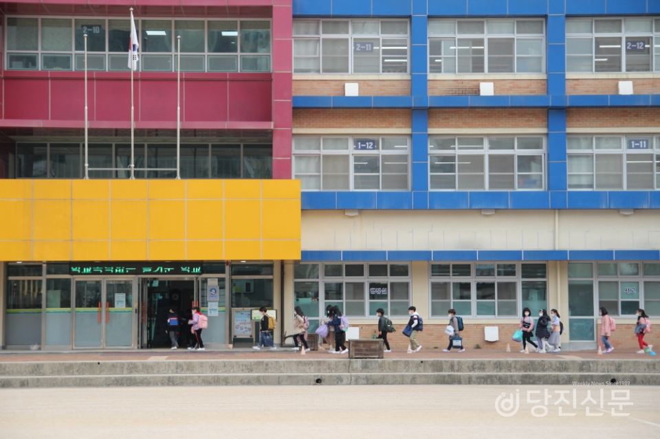 3월 19일 교실에 들어가기 전 발열 체크를 하기 위해 한 줄로 서서 기다리는 기지초 학생들. 학생들은 마스크를 쓰고 친구들과 간격을 맞춰 서서 방역 지침을 따르고 있다.