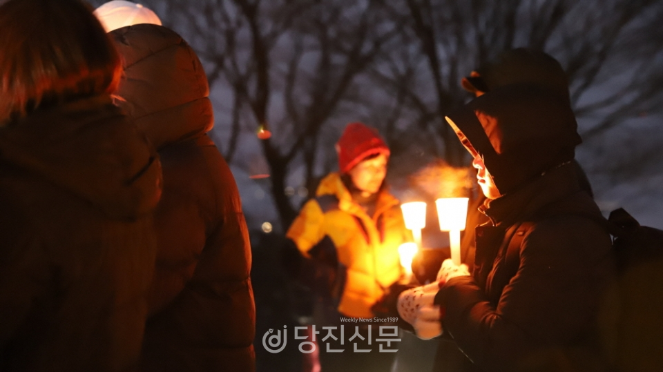 지난 1월 1일 아미산 정상에 오른 시민이 촛불을 들고 신년 소원을 빌고 있다.  이날 아미산에서 해돋이를 보기 위해 영하의 날씨에도 많은 시민이 정상에 올랐지만 기상 상태가 좋지 않아 해를 볼 수는 없어 아쉬움을 남겼다. ⓒ허미르